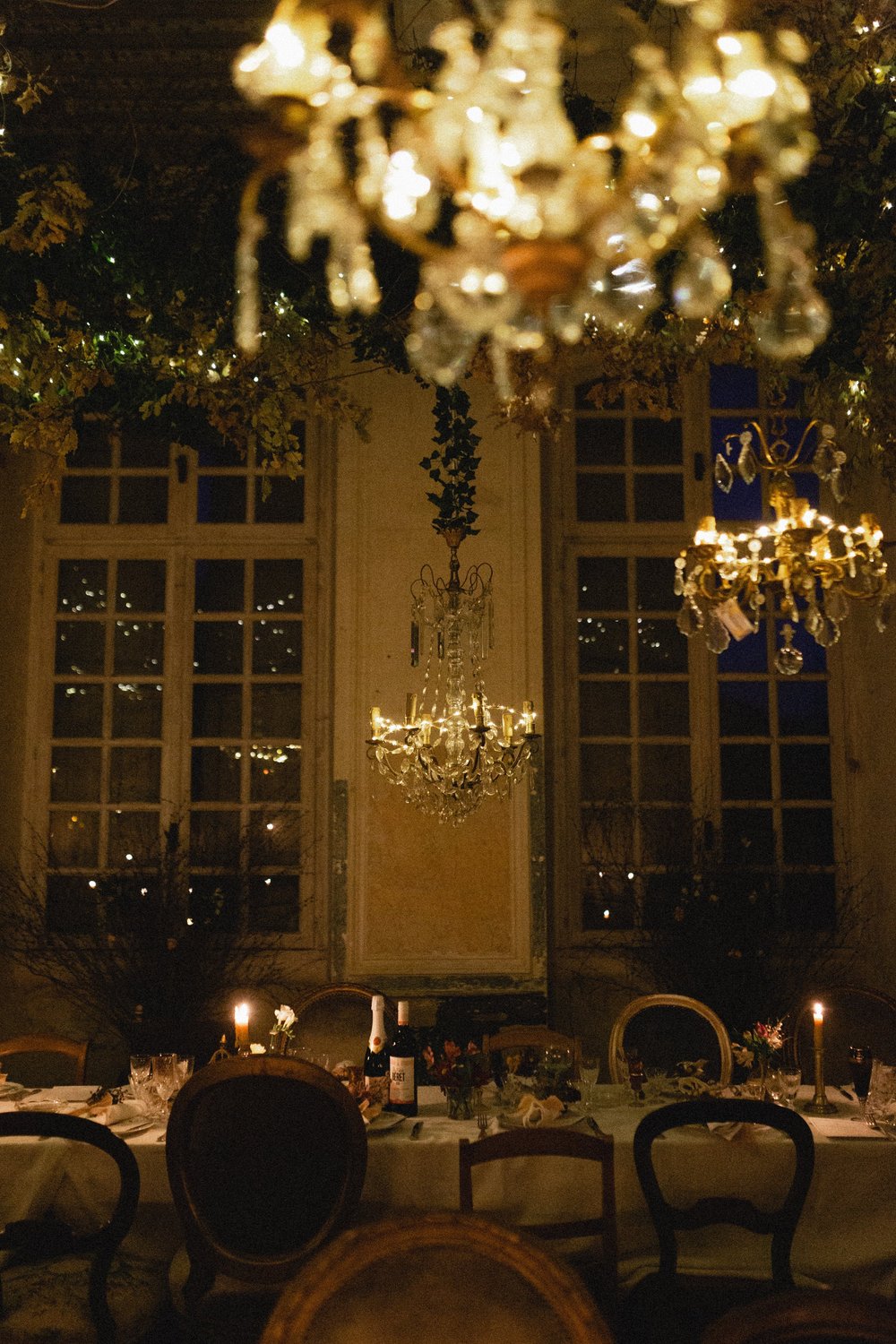 A salon at night, the chandeliers lit