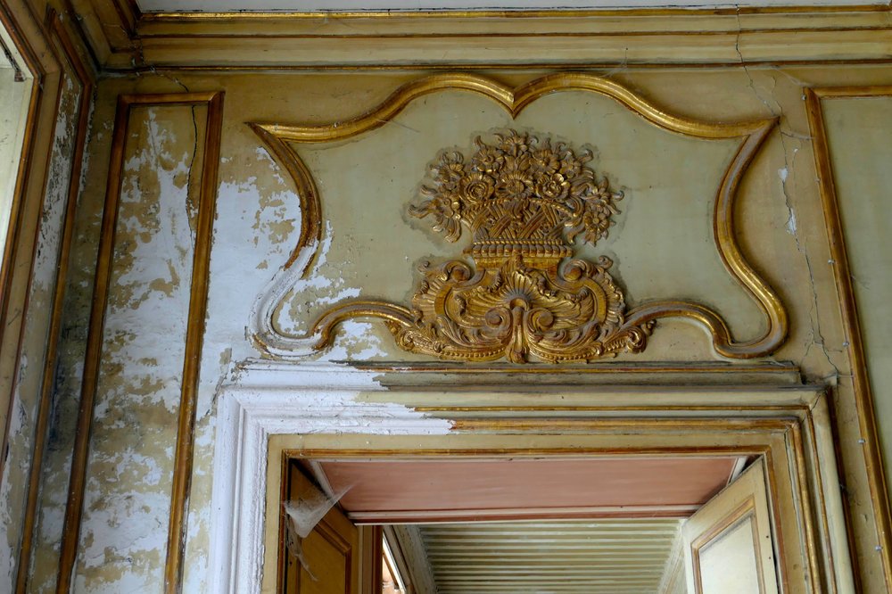 Gilt and old paint over a doorway, mid-restoration