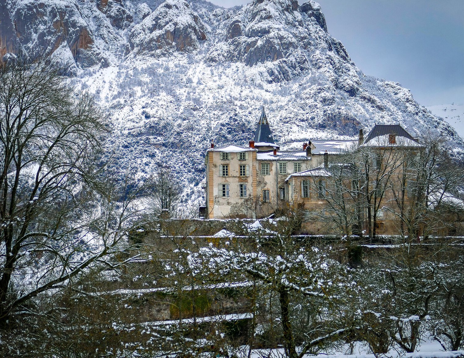 The château in snow, among the trees