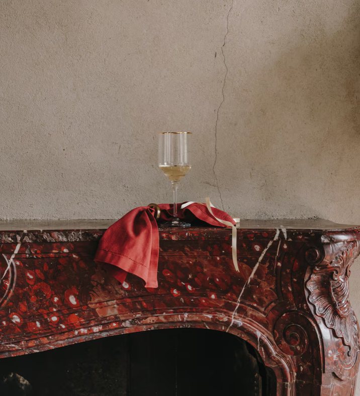 A glass of wine on the marble mantel