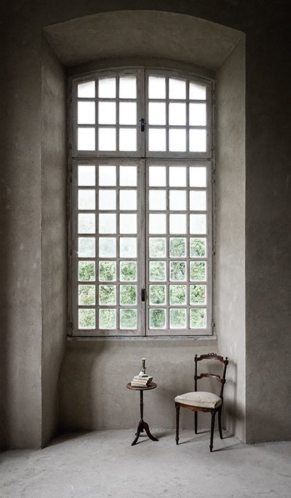 A chair by a tall window