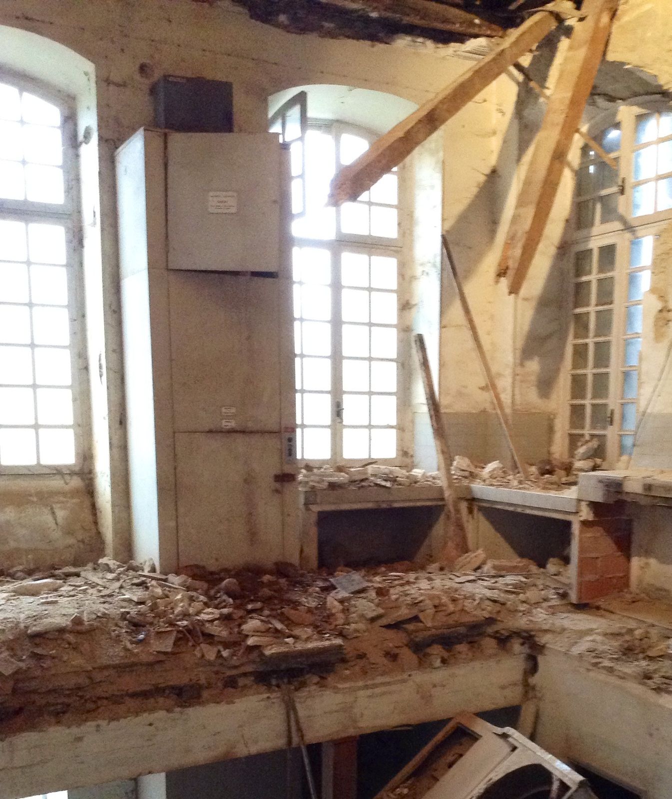 A collapsed floor beneath a tall window