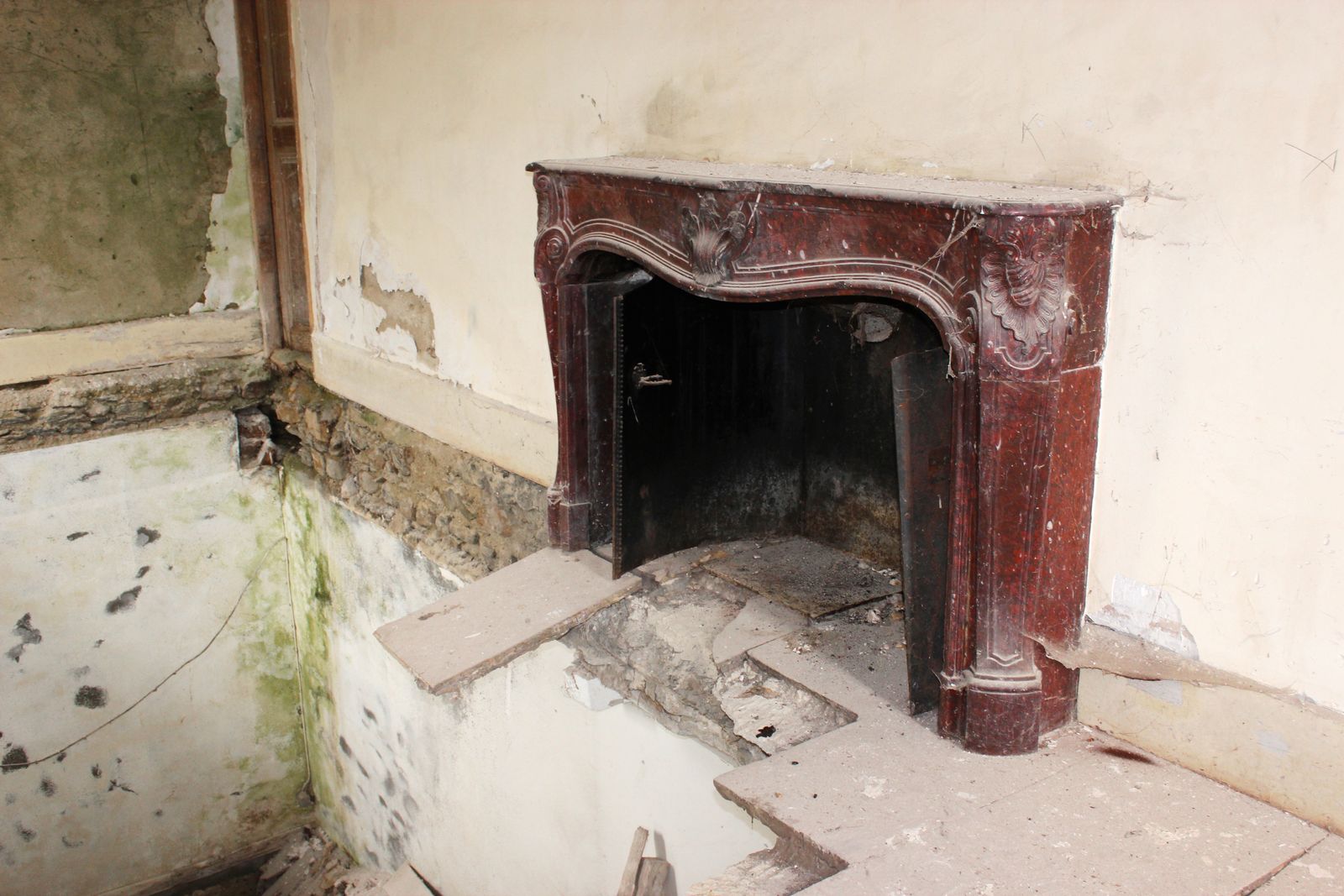 A marble mantel, the floor gone beneath it