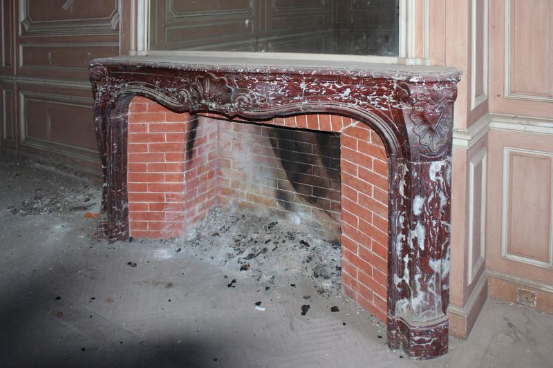 A marble fireplace in a panelled room