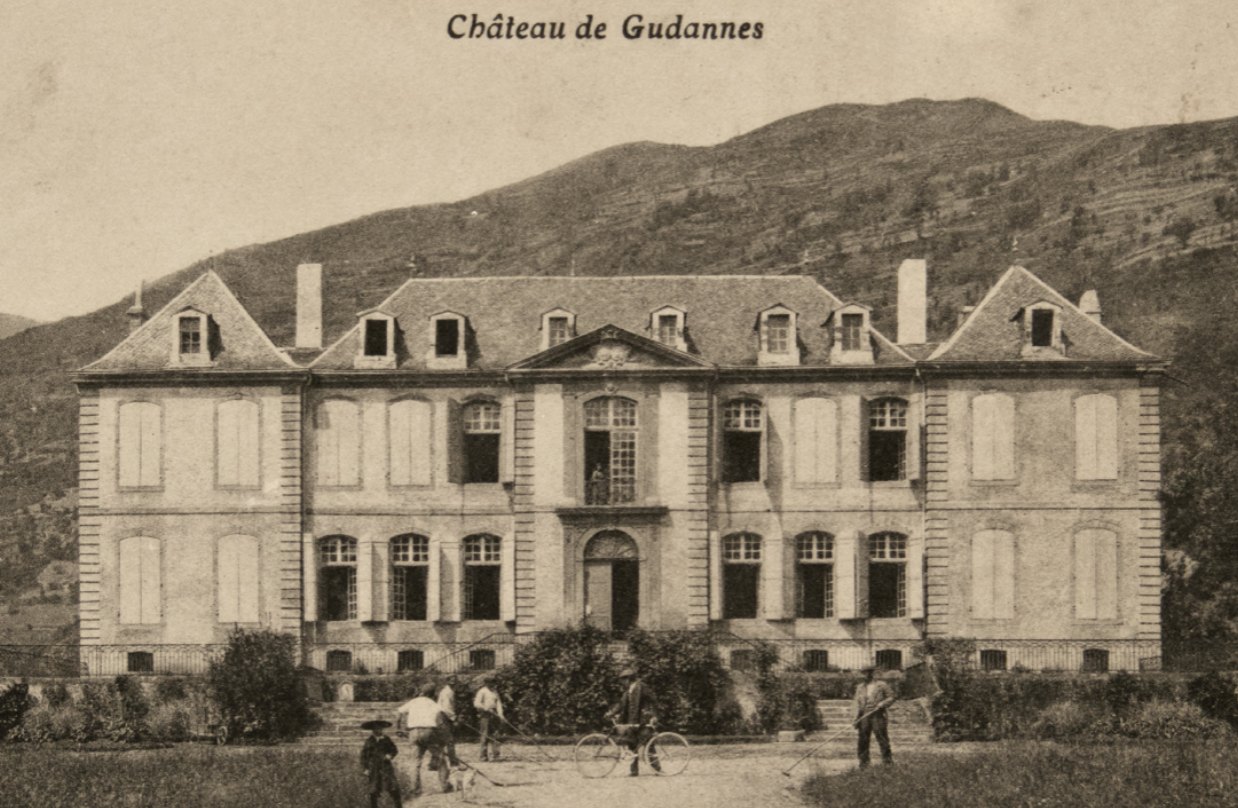 An early postcard of the château, with figures and a bicycle on the drive