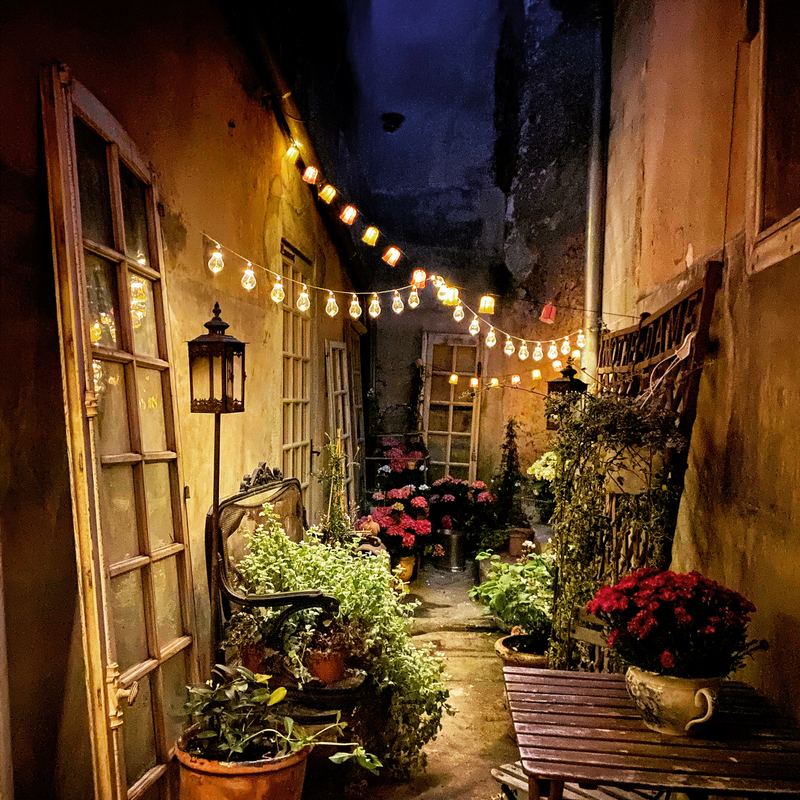 A terrace at night, strung with lights