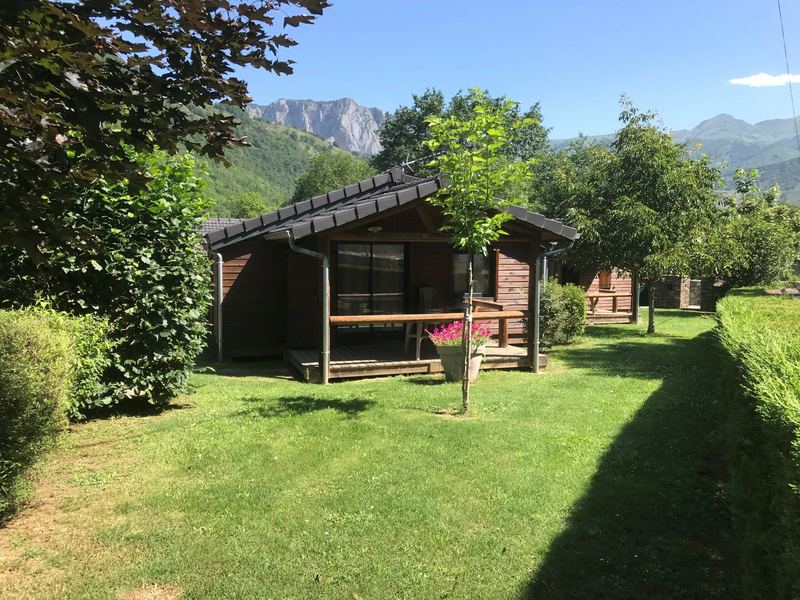A wooden chalet at Les Granges de Léo, the mountains behind