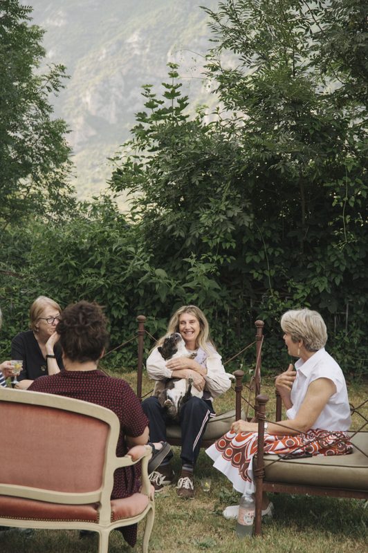 Guests talking in the garden, a dog on a lap