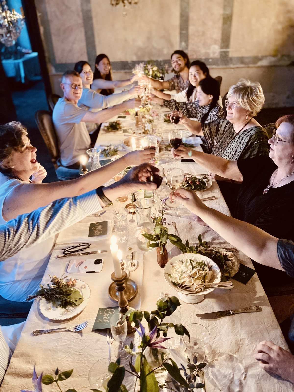 Guests raising their glasses down the long table