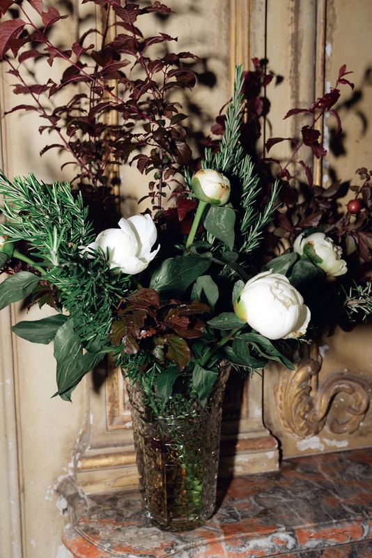 A tall vase of flowers and foliage