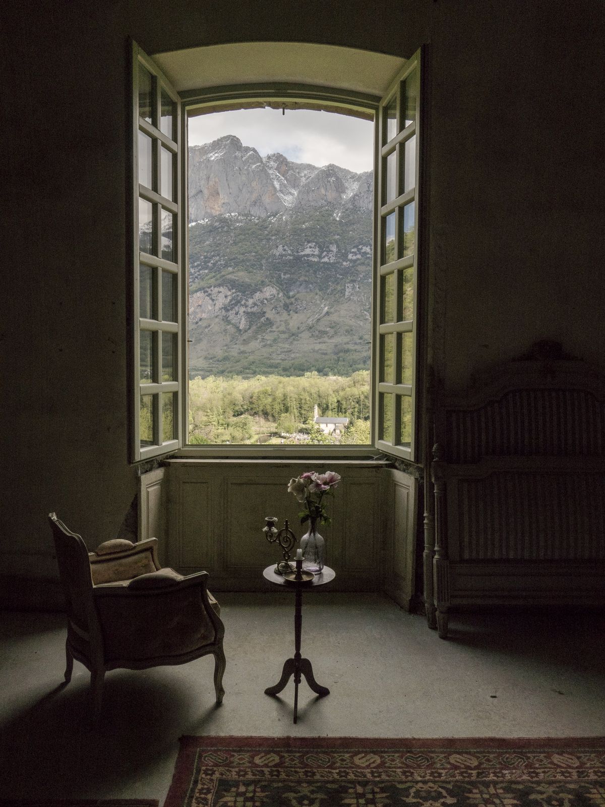 A chair by the window, the mountains beyond