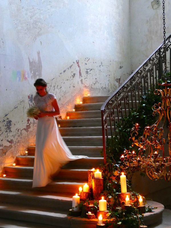 A bride coming down the candlelit staircase