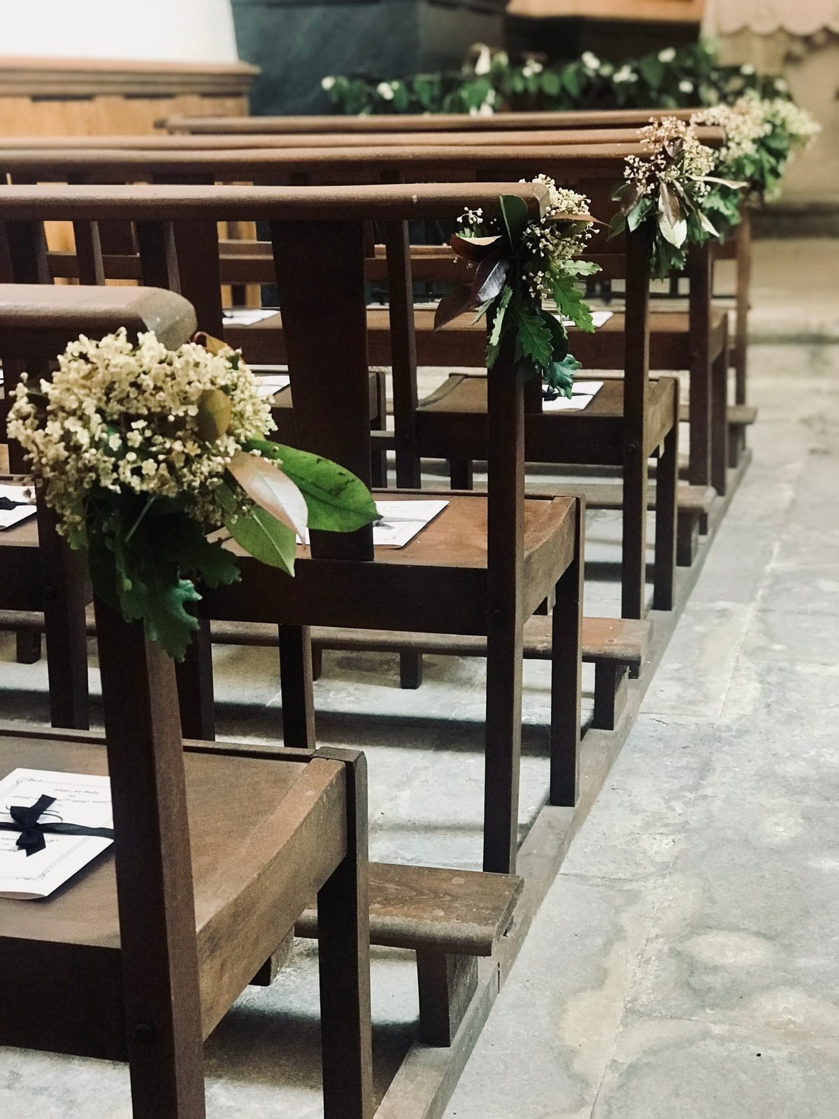 The church pews, dressed with flowers and greenery