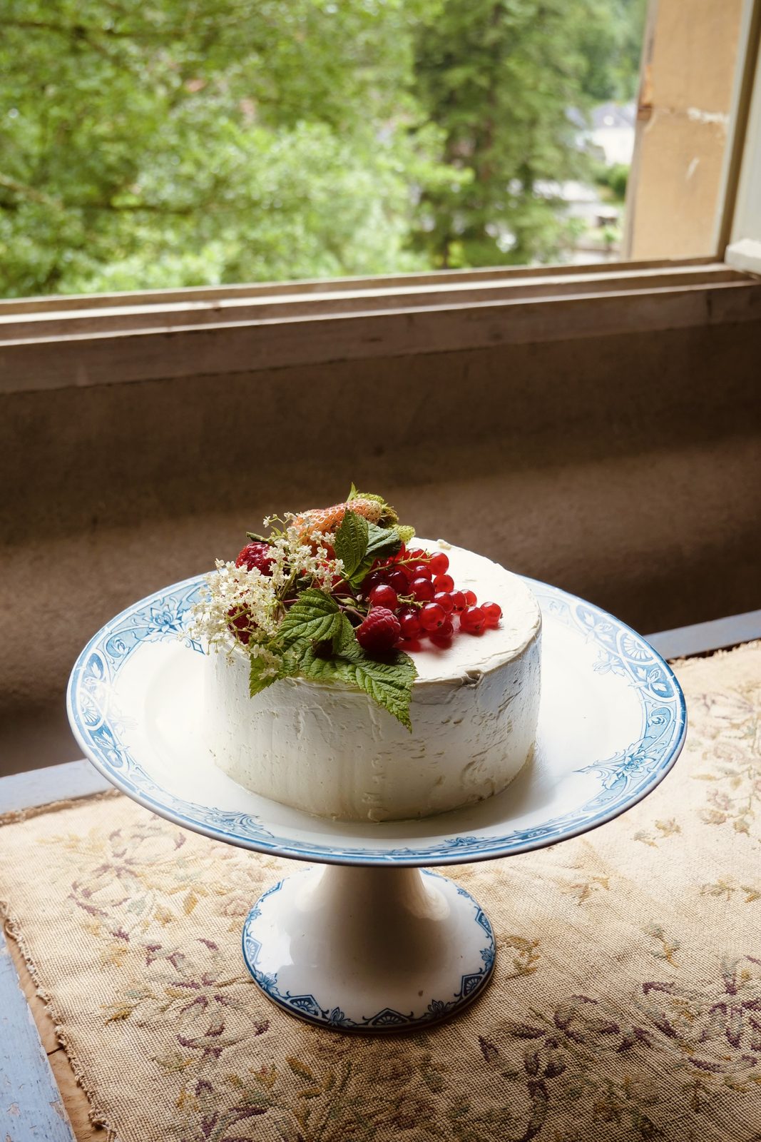 A cake on its stand by the window