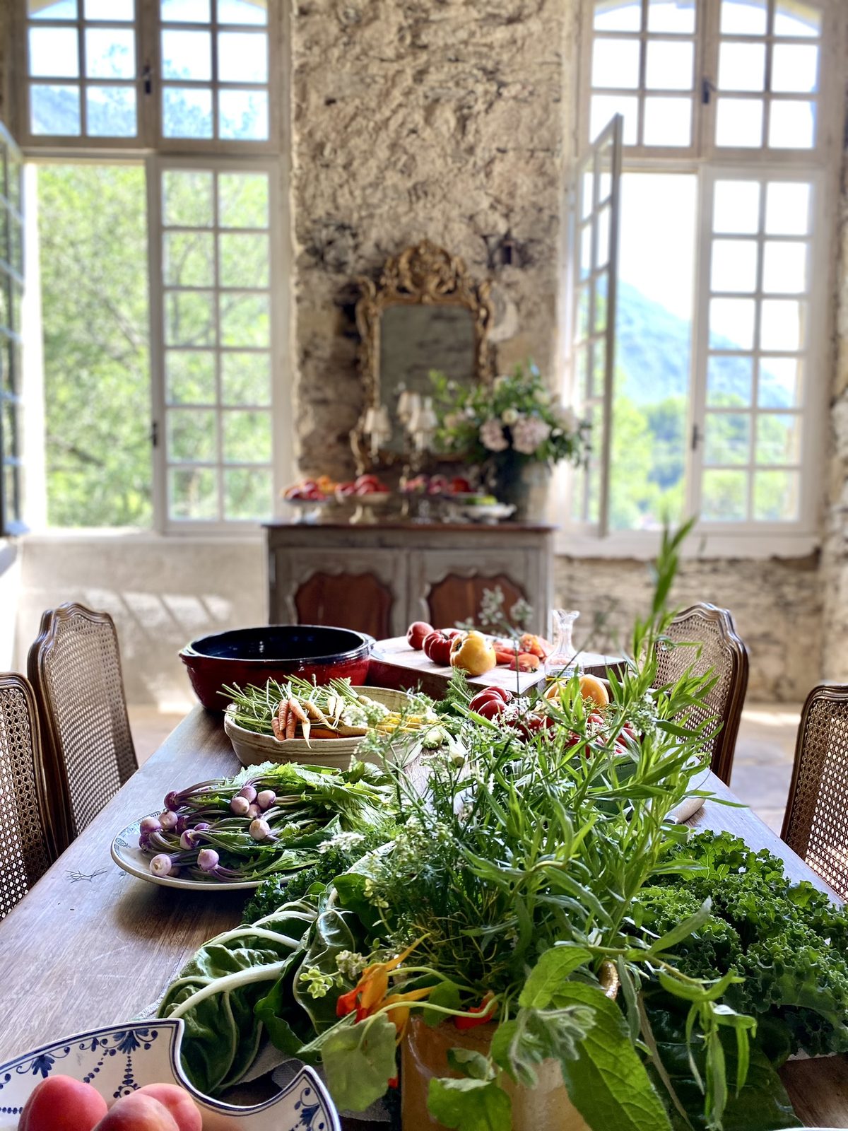 Greens on the table by the tall windows