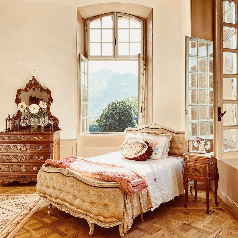 A sunlit bedroom, the mountains through the window